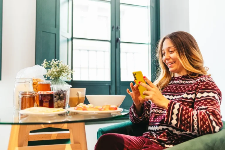 smiling-woman-using-smartphone-during-breakfast-at-2026-01-09-10-34-41-utc